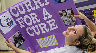 A student holds up a "ˮƵ for a Cure" sign at the Involvement Fair